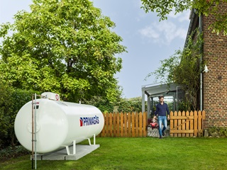 Tank im Garten vor einem Baum und einem Zaun